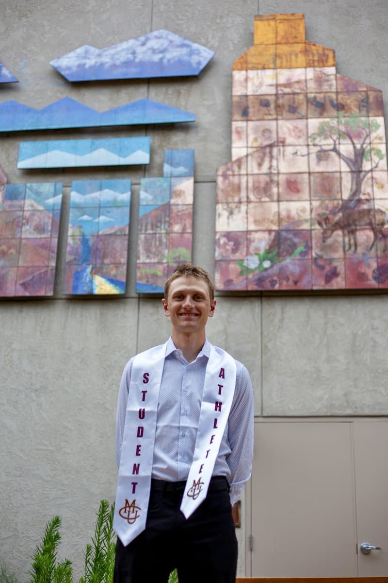 Ivan at his Colorado Mesa University graduation, wearing student and athlete sashes